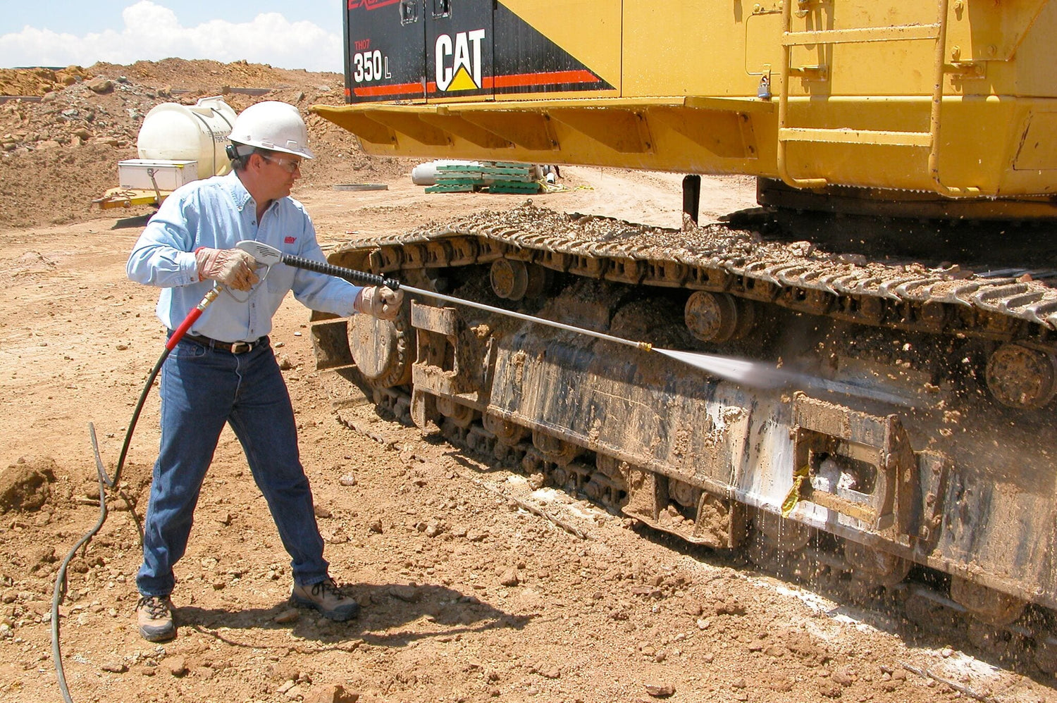 Showing a piece of heavy equipment being washed using a hotsy pressure washer on the job site.